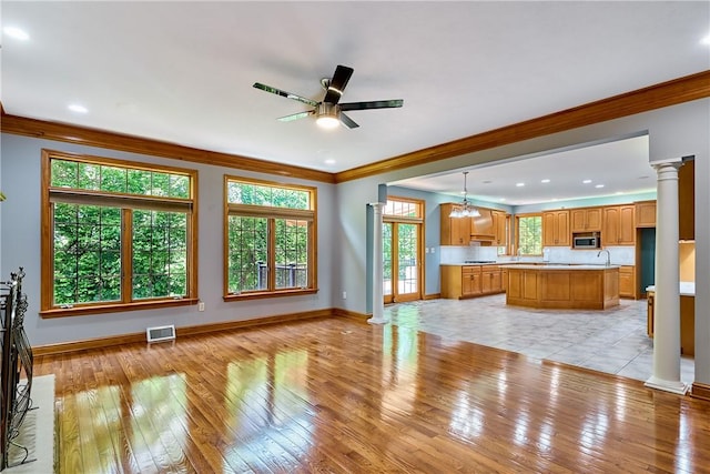 133 Ridgemont Dr, Cranberry Twp, PA 16066 - unfurnished living room featuring decorative columns, crown molding, light wood-style floors, baseboards, and ceiling fan