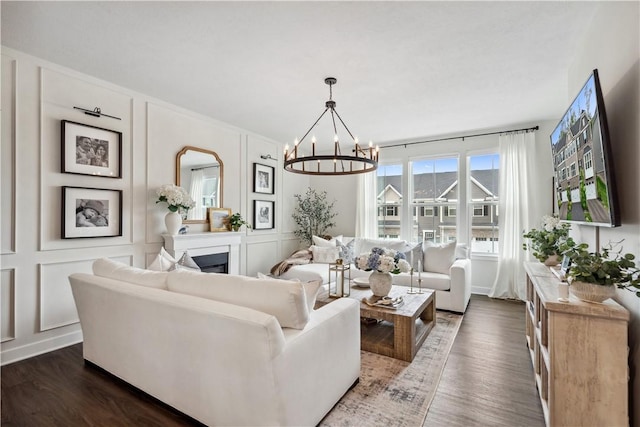 436 Greenwood Dr, North Strabane, PA 15317 - living room with a decorative wall, a fireplace, dark wood-style flooring, and a chandelier
