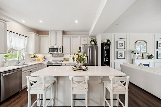 436 Greenwood Dr, North Strabane, PA 15317 - kitchen featuring appliances with stainless steel finishes, a sink, light countertops, a kitchen island, and dark wood finished floors