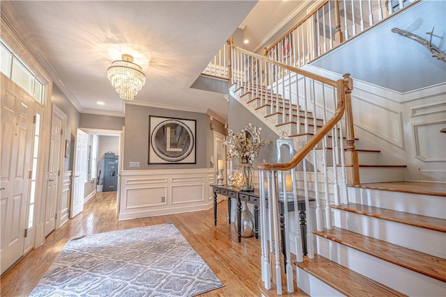 102 Maple Gln, Peters Twp, PA 15367 - foyer entrance with stairs, a decorative wall, crown molding, wood finished floors, and a chandelier