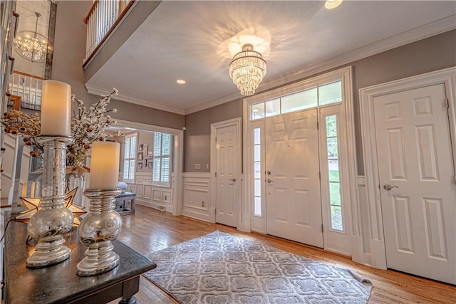 102 Maple Gln, Peters Twp, PA 15367 - entryway with a chandelier, wood finished floors, crown molding, a wainscoted wall, and a decorative wall