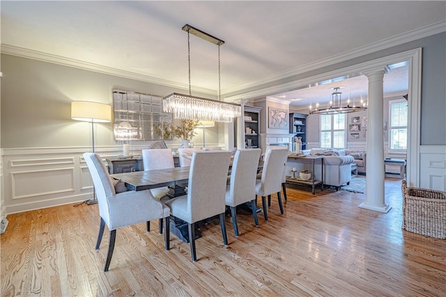 102 Maple Gln, Peters Twp, PA 15367 - dining area featuring ornate columns, a decorative wall, ornamental molding, wood finished floors, and a wainscoted wall