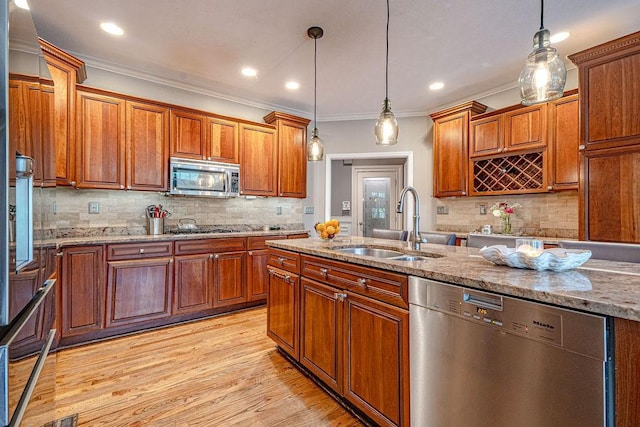 102 Maple Gln, Peters Twp, PA 15367 - kitchen with stainless steel appliances, a sink, ornamental molding, light stone counters, and light wood-type flooring