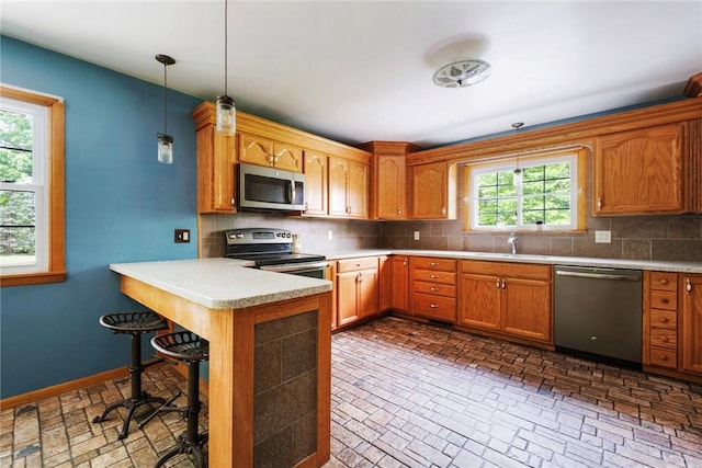 321 Green Acres Ln, Shenango Twp Law, PA 16101 - kitchen featuring appliances with stainless steel finishes, a peninsula, decorative backsplash, and brick patterned floors