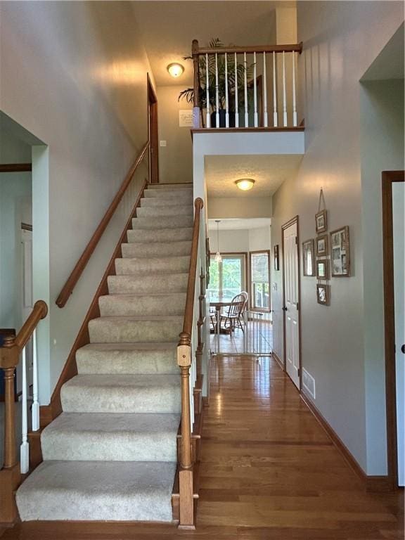 1016 Noble Pine Ct, Penn Twp Wml, PA 15085 - staircase with wood finished floors, a towering ceiling, and baseboards
