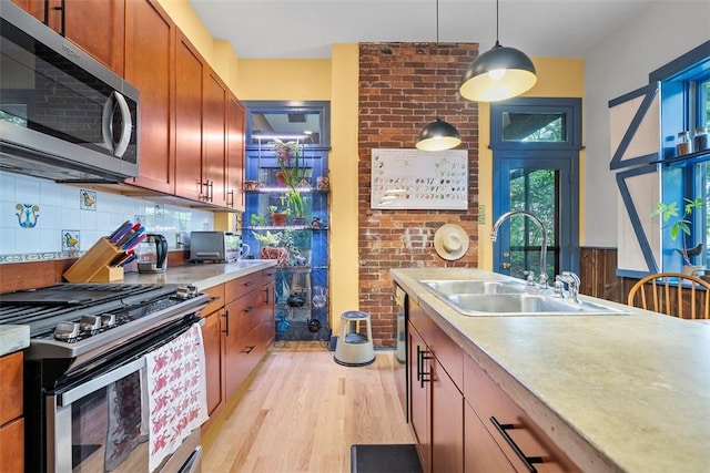534 Trenton Ave, Regent Square, PA 15221 - kitchen with appliances with stainless steel finishes, a sink, light wood-style floors, decorative light fixtures, and light countertops