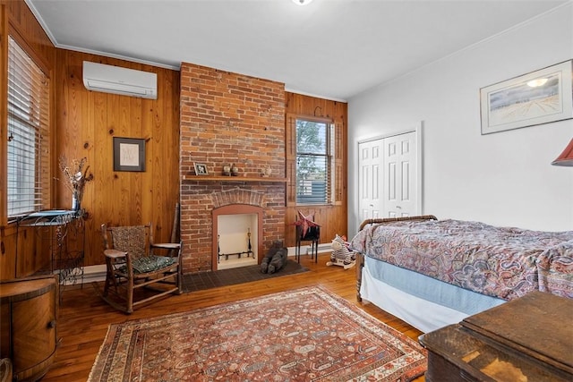 534 Trenton Ave, Regent Square, PA 15221 - bedroom with a wall mounted air conditioner, wood finished floors, wooden walls, a closet, and a fireplace