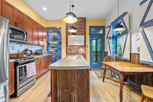534 Trenton Ave, Regent Square, PA 15221 - kitchen with stainless steel appliances, a sink, light wood-style flooring, and hanging light fixtures