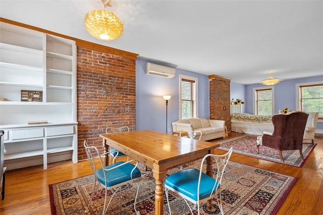 534 Trenton Ave, Regent Square, PA 15221 - dining space featuring a wall unit AC, light wood-style floors, and brick wall