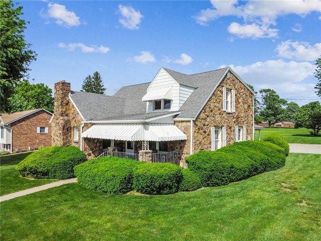 1068 Lakeview Dr, Unity Twp, PA 15650 - view of front facade featuring stone siding, a front lawn, a chimney, and roof with shingles