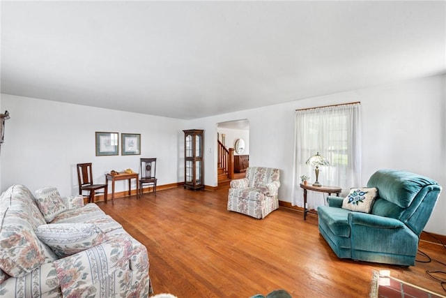 1068 Lakeview Dr, Unity Twp, PA 15650 - living room featuring stairs, wood finished floors, arched walkways, and baseboards