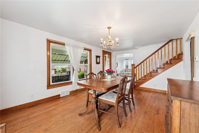 1068 Lakeview Dr, Unity Twp, PA 15650 - dining area with a chandelier, stairs, healthy amount of natural light, and light wood-style floors