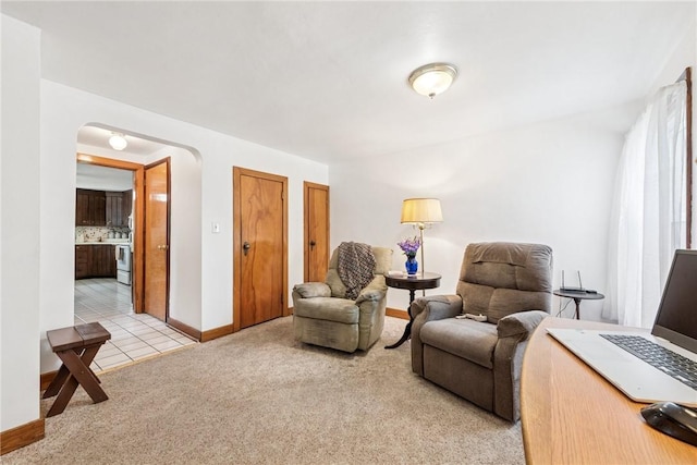 1068 Lakeview Dr, Unity Twp, PA 15650 - living room featuring arched walkways, light carpet, baseboards, and light tile patterned floors