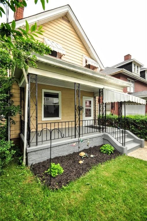 222 Orchard Ave, Canonsburg, PA 15317 - view of front of house featuring covered porch, a chimney, and a front lawn
