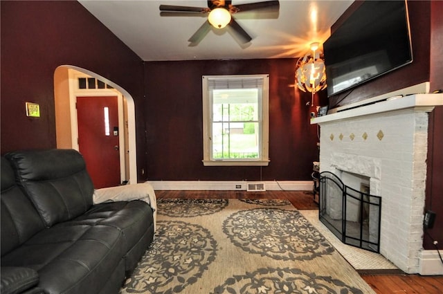 222 Orchard Ave, Canonsburg, PA 15317 - living area with wood finished floors, ceiling fan, baseboards, a fireplace, and arched walkways