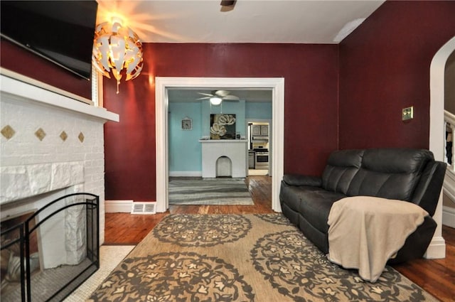 222 Orchard Ave, Canonsburg, PA 15317 - living room featuring a brick fireplace, wood finished floors, arched walkways, and ceiling fan