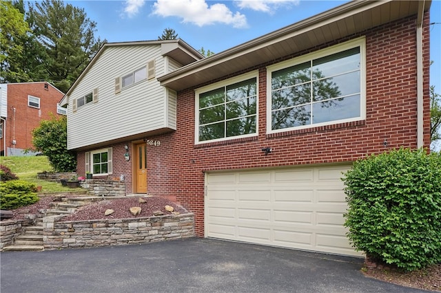 5849 Wilson Dr, Bethel Park, PA 15102 - tri-level home featuring a garage, driveway, and brick siding