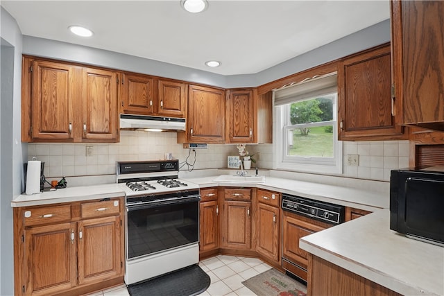 5849 Wilson Dr, Bethel Park, PA 15102 - kitchen with white gas range oven, paneled dishwasher, under cabinet range hood, black microwave, and brown cabinets