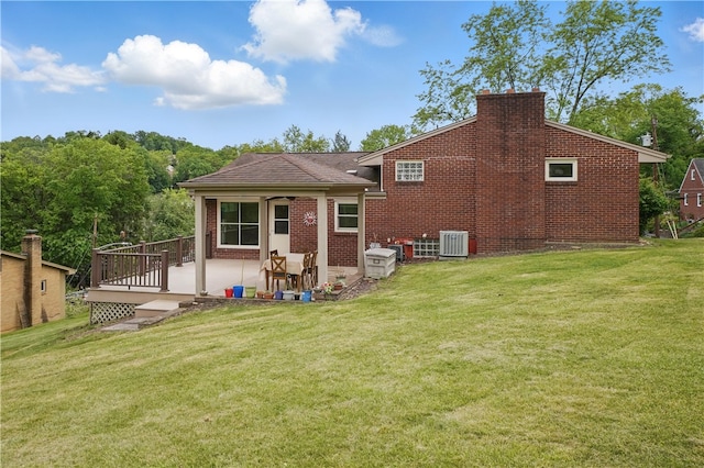5849 Wilson Dr, Bethel Park, PA 15102 - back of property featuring central AC, a lawn, a chimney, brick siding, and a patio