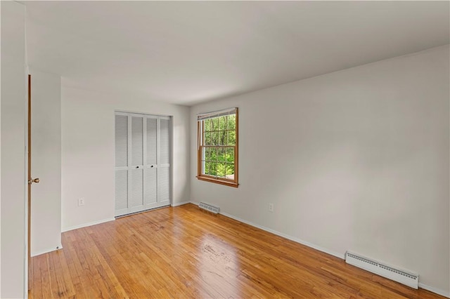 187 Friar Ln, Peters Twp, PA 15317 - unfurnished bedroom featuring a baseboard heating unit, light wood-style floors, a closet, and baseboards