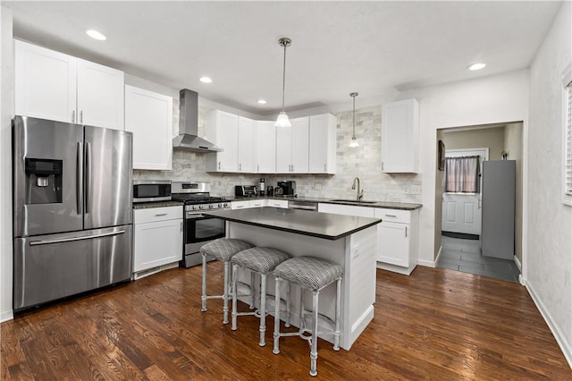 239 Albert St, Mt Washington, PA 15211 - kitchen featuring appliances with stainless steel finishes, wall chimney range hood, a sink, dark countertops, and a breakfast bar area