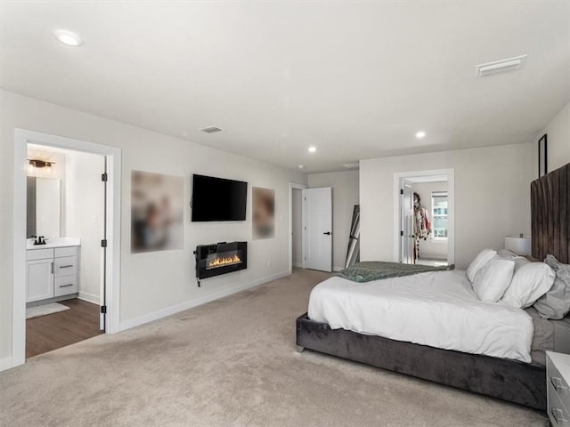 127 Red Horse Dr, Buffalo Twp, PA 16055 - bedroom with light colored carpet, a glass covered fireplace, recessed lighting, baseboards, and ensuite bathroom