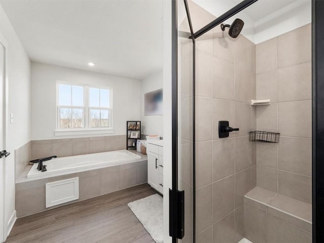 127 Red Horse Dr, Buffalo Twp, PA 16055 - full bath featuring wood finished floors, a stall shower, a garden tub, vanity, and recessed lighting