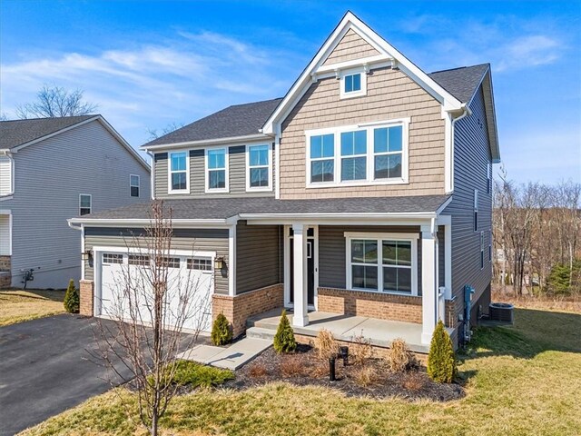 127 Red Horse Dr, Buffalo Twp, PA 16055 - craftsman-style home with a porch, driveway, brick siding, a front yard, and a garage