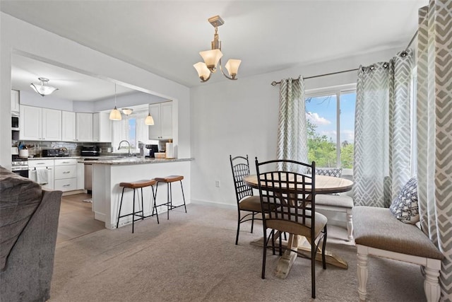 3050 S Park Rd, Bethel Park, PA 15102 - carpeted dining space with a sink, a chandelier, and baseboards