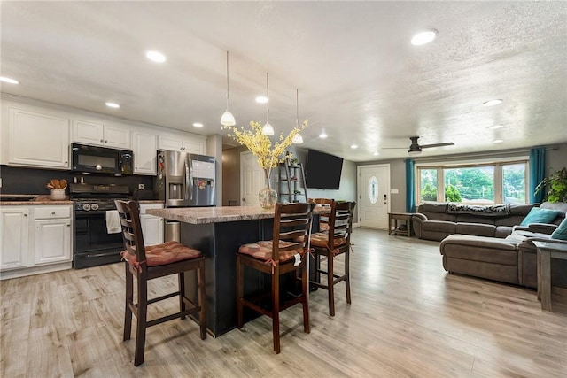 415 Governor Dr, Shaler, PA 15101 - kitchen with black appliances, open floor plan, white cabinets, light wood finished floors, and a kitchen breakfast bar
