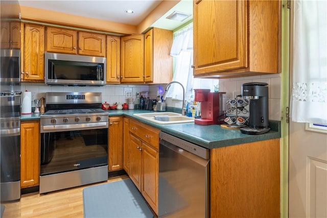 600 Margaret St, Mount Oliver, PA 15210 - kitchen with stainless steel appliances, a sink, brown cabinets, tasteful backsplash, and recessed lighting
