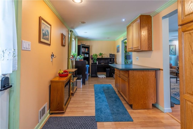 600 Margaret St, Mount Oliver, PA 15210 - kitchen with crown molding, light wood-type flooring, brown cabinets, recessed lighting, and dark countertops