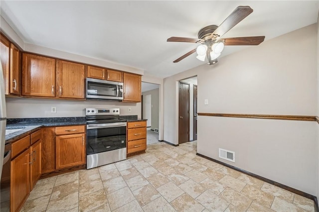 1056 Mcallister Dr, Plum Boro, PA 15068 - kitchen featuring stainless steel appliances, brown cabinets, a ceiling fan, and baseboards