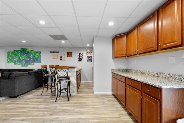 97 Clover Ln, Pine Twp Nal, PA 15044 - kitchen with light wood-type flooring, light stone counters, brown cabinets, recessed lighting, and baseboards