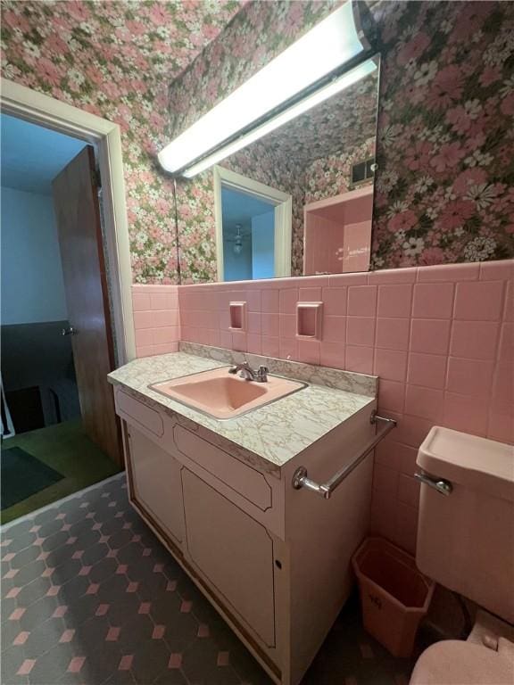 1929 Alcoa Dr, Arnold, PA 15068 - half bathroom with wallpapered walls, tile walls, vanity, a wainscoted wall, and tile patterned floors