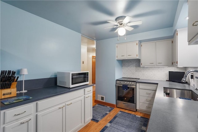 441 Wyndhurst Dr, Moon/Crescent Twp, PA 15108 - kitchen featuring stainless steel range with electric cooktop, white microwave, a sink, ceiling fan, and backsplash