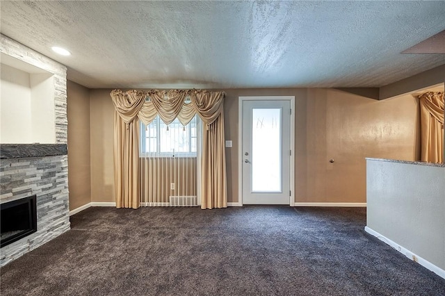 62 Spring St, Etna, PA 15223 - unfurnished living room featuring a fireplace, a textured ceiling, dark colored carpet, and baseboards