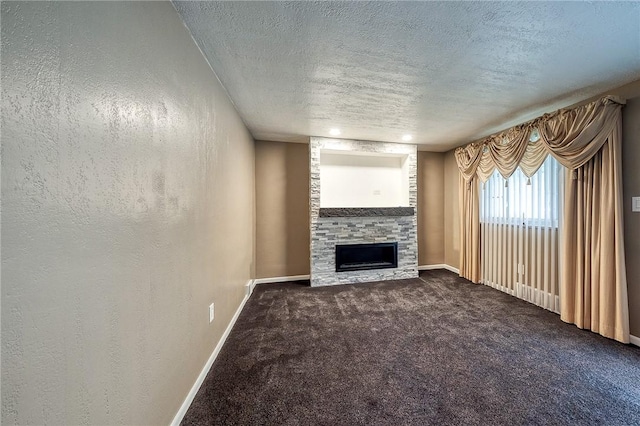 62 Spring St, Etna, PA 15223 - unfurnished living room featuring a textured ceiling, a stone fireplace, carpet floors, baseboards, and a textured wall