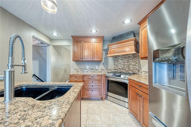 62 Spring St, Etna, PA 15223 - kitchen featuring appliances with stainless steel finishes, a sink, decorative backsplash, custom exhaust hood, and light stone counters