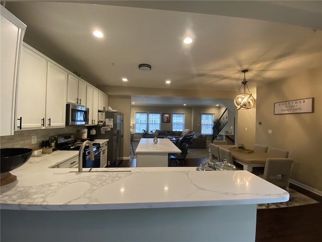 173 Rylie Dr, Lehigh Twp, PA 16037 - kitchen featuring stainless steel appliances, a peninsula, tasteful backsplash, white cabinetry, and hanging light fixtures