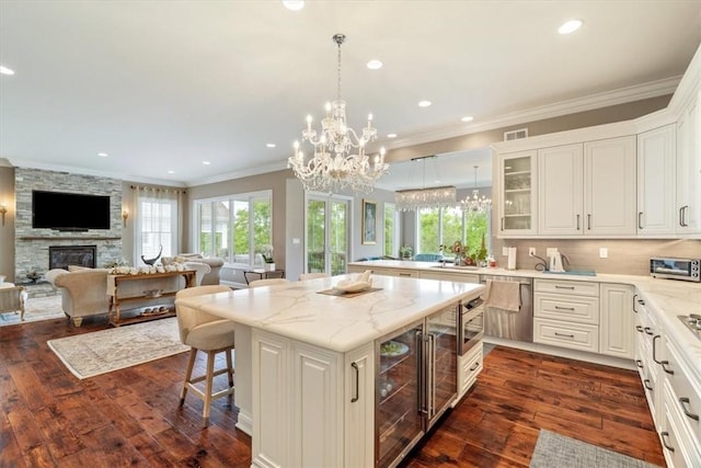 1690 Shelburne Ln, Squirrel Hill, PA 15217 - kitchen with open floor plan, dark wood-style flooring, glass insert cabinets, a kitchen island, and ornamental molding