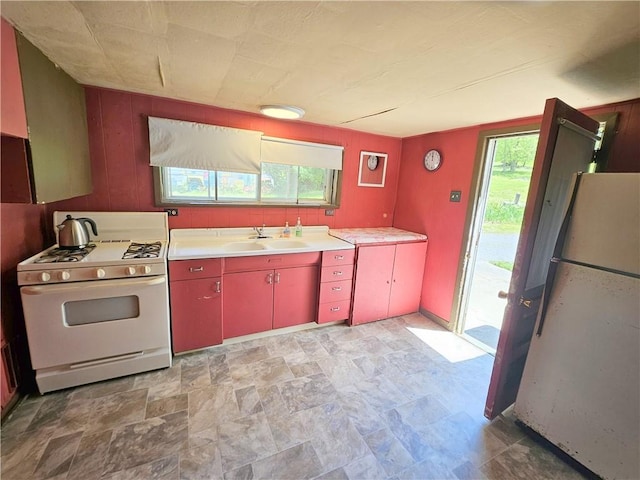 114 Leonard Rd, Washington Twp But, PA 16040 - kitchen featuring white appliances, red cabinets, a sink, light countertops, and wooden walls