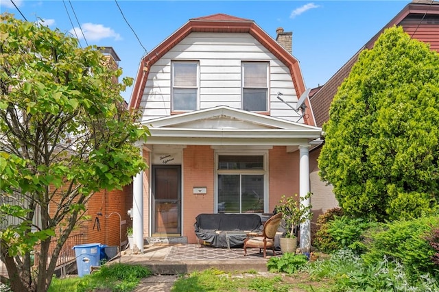 1318 Princess Ave, Beechview, PA 15216 - view of front of home featuring a gambrel roof, a chimney, covered porch, and brick siding