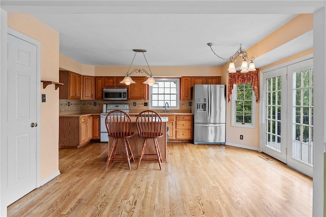 16 Mcbride Rd, North Strabane, PA 15317 - kitchen with stainless steel appliances, a sink, light wood-style floors, decorative backsplash, and brown cabinets