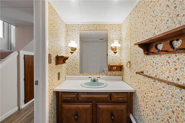 2418 Graceland Rd, Neshannock Twp, PA 16105 - half bath featuring vanity, ornamental molding, wood finished floors, and wallpapered walls