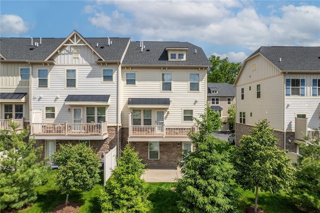876 Beacon Ln, Mccandless, PA 15237 - back of house with board and batten siding, stone siding, a patio area, a residential view, and a shingled roof
