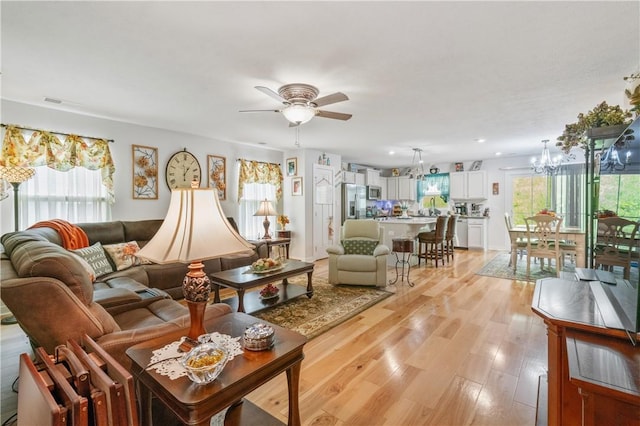 153 Olivia Dr, Center Twp Bea, PA 15061 - living room with a chandelier, a ceiling fan, and light wood-style flooring