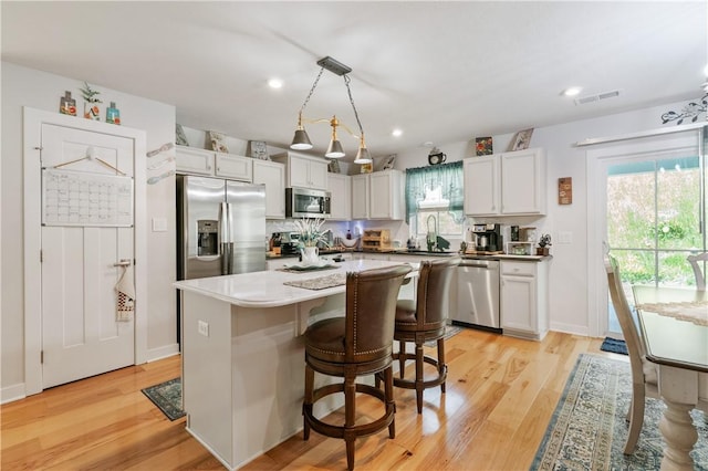 153 Olivia Dr, Center Twp Bea, PA 15061 - kitchen with appliances with stainless steel finishes, light wood-style floors, a kitchen island, white cabinets, and recessed lighting