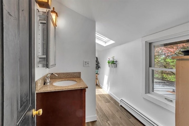 439 Pleasant Hill Rd, Allegheny Twp Wml, PA 15656 - bathroom with baseboard heating, a skylight, wood finished floors, vanity, and baseboards