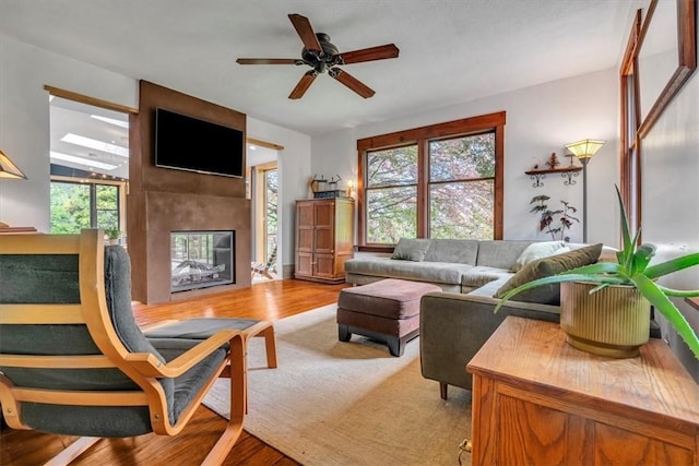 439 Pleasant Hill Rd, Allegheny Twp Wml, PA 15656 - living room featuring a multi sided fireplace, healthy amount of natural light, wood finished floors, and ceiling fan